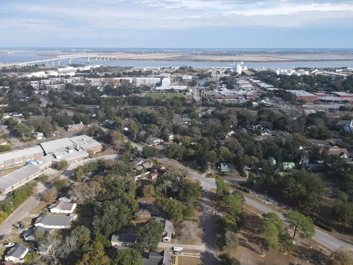 A vibrant view showing the bridge, waterfront areas, city skyline, and charming residential neighborhoods of Charleston. The scene is lively and inviting, hinting at opportunities for walking along the waterfront, attending local festivals, and discovering the diverse mix of urban and natural landscapes.