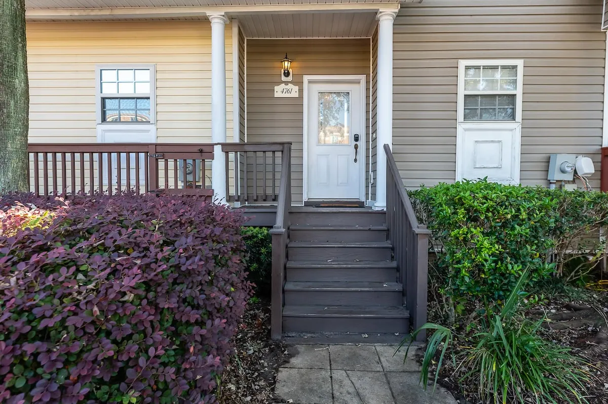 An exterior view showing the home's front door, steps, attractive landscaping, and a welcoming light fixture. The setup highlights the initial curb appeal and the approach to entering the property, creating a positive first impression for guests.