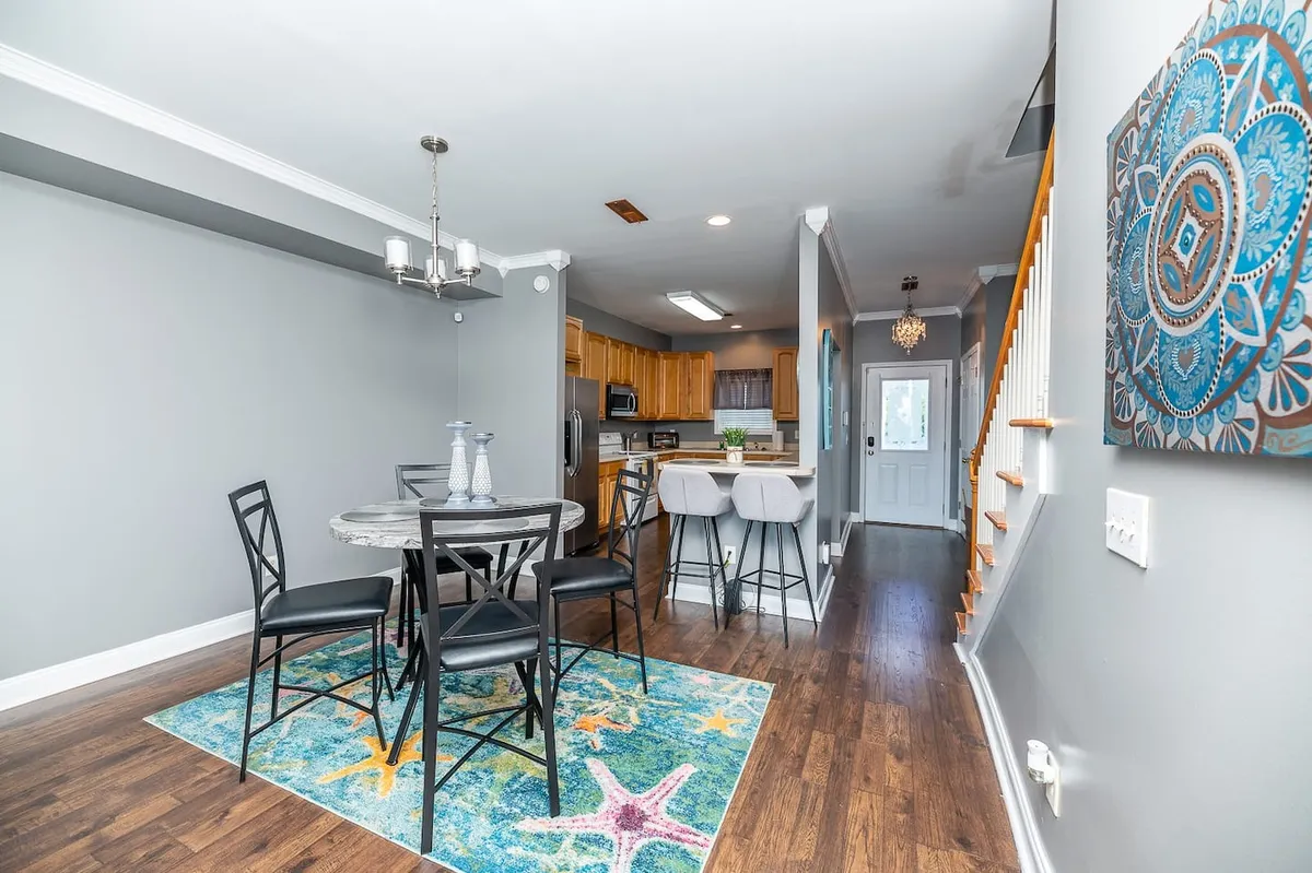 A cheerful dining space with a central dining table set atop a playful starfish rug, seamlessly connected to the adjoining kitchen. The area is bright and welcoming, designed for sharing meals and lively gatherings just steps from meal preparation spaces.
